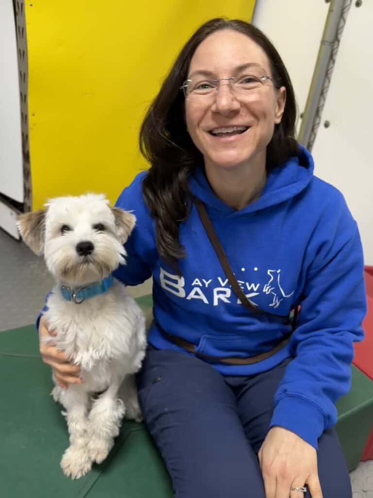 smiley woman taking care of a white cute dog
